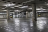 an empty parking garage with stairs and concrete walls is pictured in this image taken in daylight