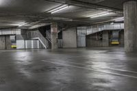 an empty parking garage with stairs and concrete walls is pictured in this image taken in daylight