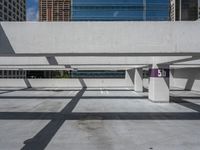 a parking garage with lots of empty spaces in front of tall buildings with glass windows