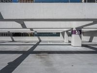 a parking garage with lots of empty spaces in front of tall buildings with glass windows