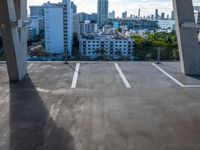 an empty parking garage in the middle of city with tall buildings in the background of it