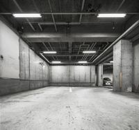 an empty parking garage that is grey and white with no signs on the floor of the garage