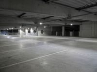 a empty parking garage with a row of parking meters in the center and lights on