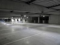 a empty parking garage with a row of parking meters in the center and lights on