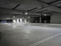 a empty parking garage with a row of parking meters in the center and lights on