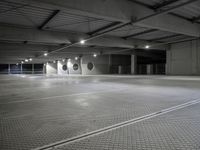 a empty parking garage with a row of parking meters in the center and lights on