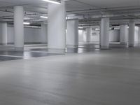 the empty parking garage is full of empty cars or trucks at night time in a white room