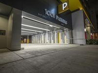 an empty parking garage at night with light on the doors and parking spaces on either side