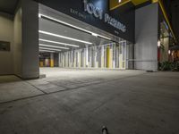 an empty parking garage at night with light on the doors and parking spaces on either side