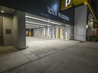 an empty parking garage at night with light on the doors and parking spaces on either side