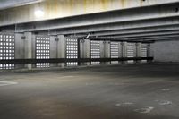 an empty parking garage filled with gray cement and windows that are open to reveal the space for skateboards
