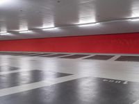 a large red box in an empty parking garage area with several boxes and a fire hydrant