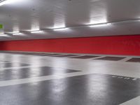 a large red box in an empty parking garage area with several boxes and a fire hydrant