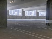 this is an empty parking garage space with a view of the city in the background