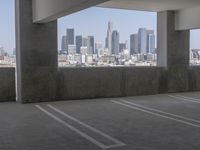 this is an empty parking garage space with a view of the city in the background