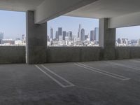 this is an empty parking garage space with a view of the city in the background