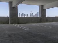 this is an empty parking garage space with a view of the city in the background