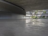 an empty parking garage with concrete floors and walls and no chairs in it and palm trees