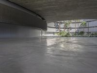 an empty parking garage with concrete floors and walls and no chairs in it and palm trees