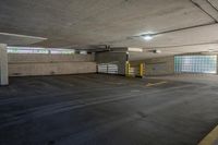 an empty parking garage with no one sitting inside of it near a fire hydrant