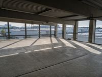 an empty parking garage with a long walkway leading to it's door and a view of a waterway