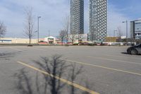 the empty parking lot of the apartment complex at the edge of the park in the city