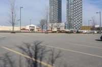 the empty parking lot of the apartment complex at the edge of the park in the city