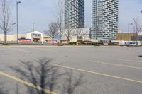 the empty parking lot of the apartment complex at the edge of the park in the city