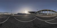 a fish eye lens view of the parking lot and outside of airport buildings that are empty