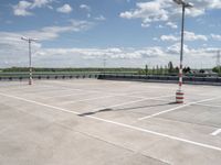 a empty parking lot next to an airport with a sky background and some white and orange stripes