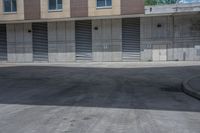 a empty parking lot in an apartment building with shutter open and a small red fire hydrant