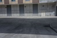 a empty parking lot in an apartment building with shutter open and a small red fire hydrant