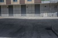 a empty parking lot in an apartment building with shutter open and a small red fire hydrant