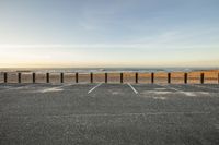 an empty parking lot with a beach in the background at sunrise - looking across to the ocean