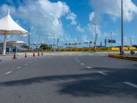 the empty parking lot of the beach side airport in the daytime, with bright clouds overhead