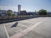 an empty parking lot next to an overpass with the name on it's side