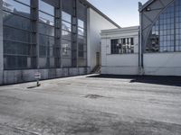 an empty parking lot with several windows and a sign in the foreground with a red and white pole