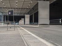 an empty parking lot under a garage at night time with the light on and no traffic