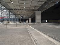 an empty parking lot under a garage at night time with the light on and no traffic