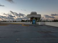 an empty parking lot with a blue door on it's front side against a cloudy sky