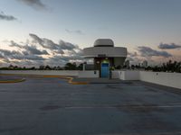 an empty parking lot with a blue door on it's front side against a cloudy sky