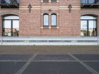 there is an empty parking lot in front of a brick building with many windows on the side