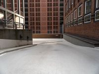 an empty, empty parking lot near a brick building that has windows with bars attached to it