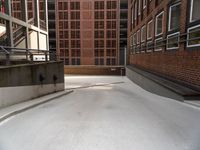 an empty, empty parking lot near a brick building that has windows with bars attached to it