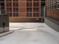 an empty, empty parking lot near a brick building that has windows with bars attached to it