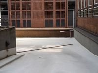 an empty, empty parking lot near a brick building that has windows with bars attached to it