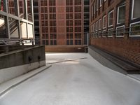 an empty, empty parking lot near a brick building that has windows with bars attached to it