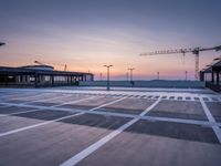 a parking lot with lots of empty parking lot space at sunset time with a building in the background