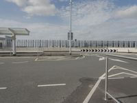 an empty parking lot next to two buildings with some traffic barriers around it and a light pole in the background