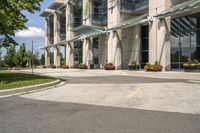 an empty parking lot with a canopy over the street, surrounded by many different planters and flowers